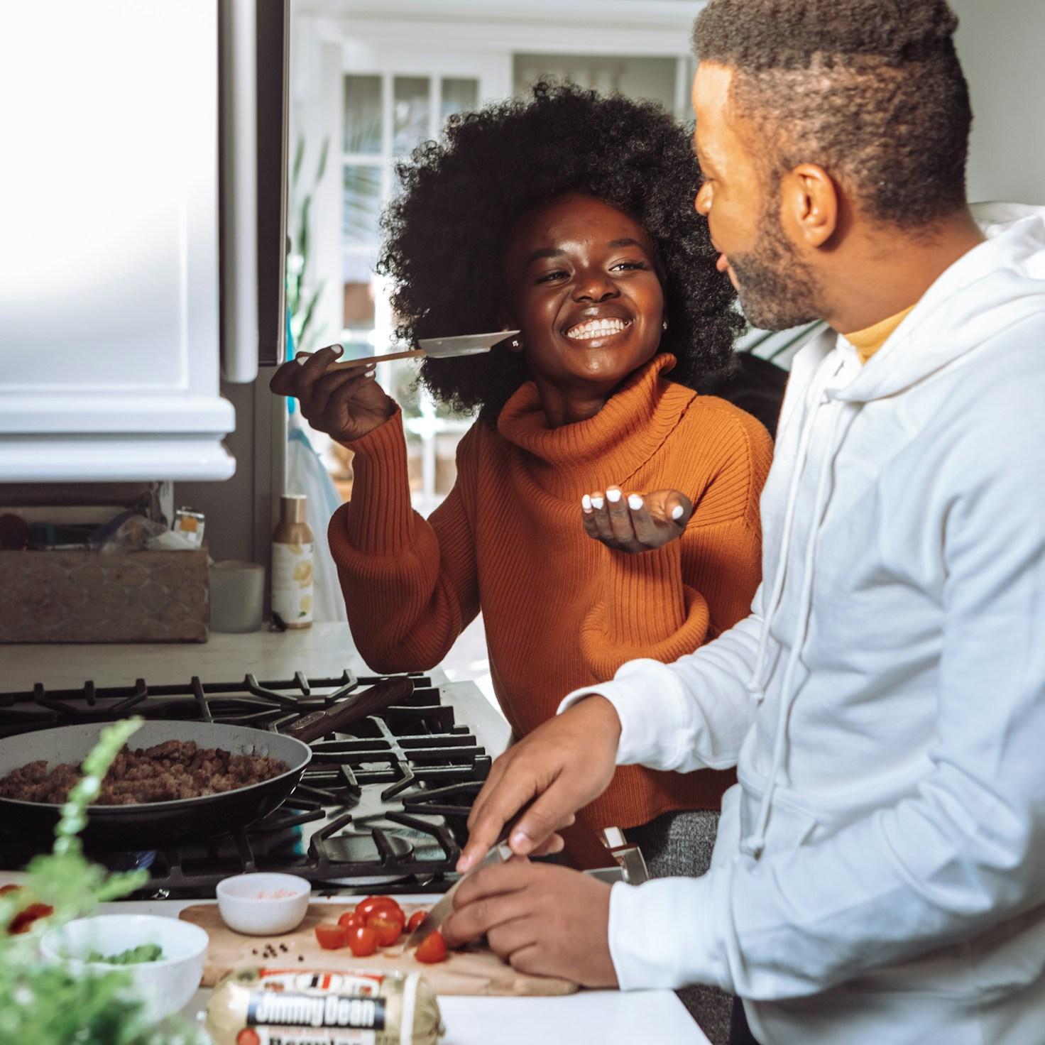 Community members working together in a contemporary kitchen space, exchanging recipes and culinary techniques
